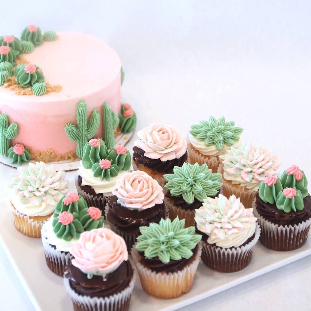 A pink celebration cake and assorted cupcakes decorated with buttercream succulents at Lilac Pâtisserie.