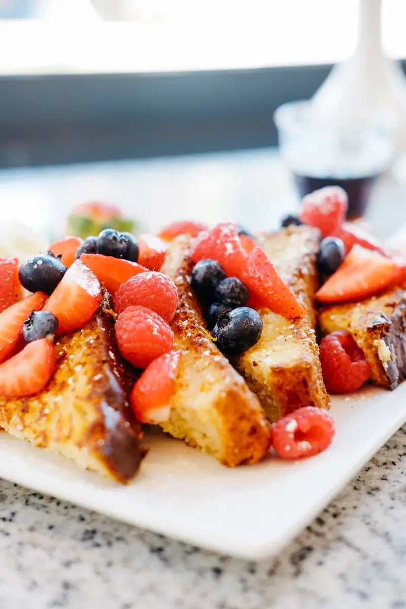 Thick-cut gluten-free brioche French toast topped with fresh mixed berries.