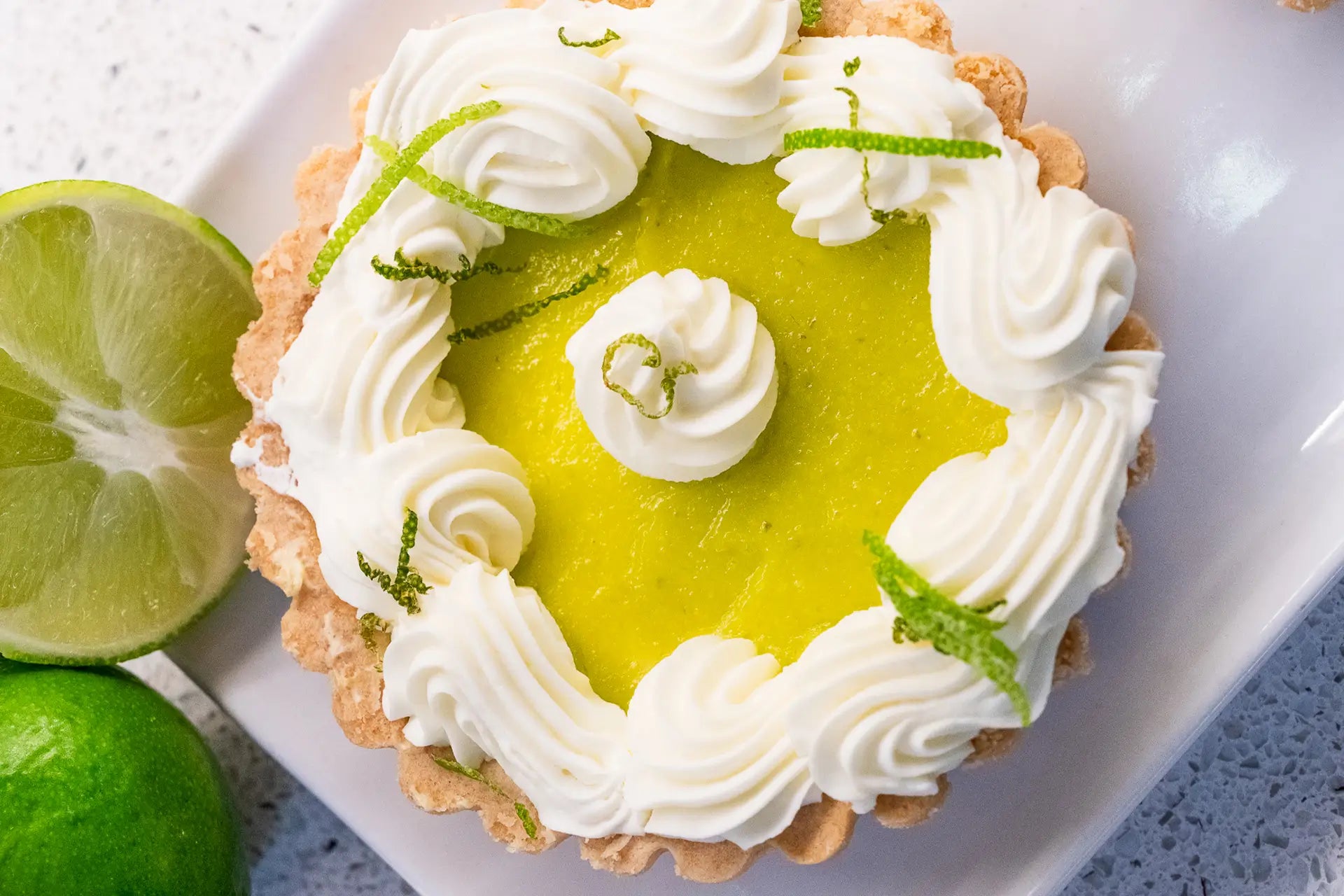 Key lime tart with whipped cream and fresh lime zest
