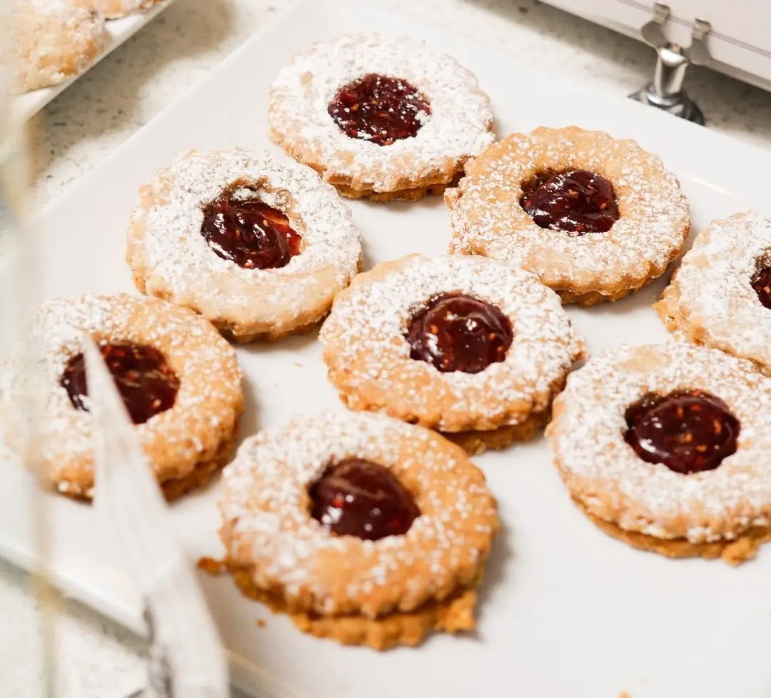 Powdered sugar Linzer cookies filled with raspberry jam